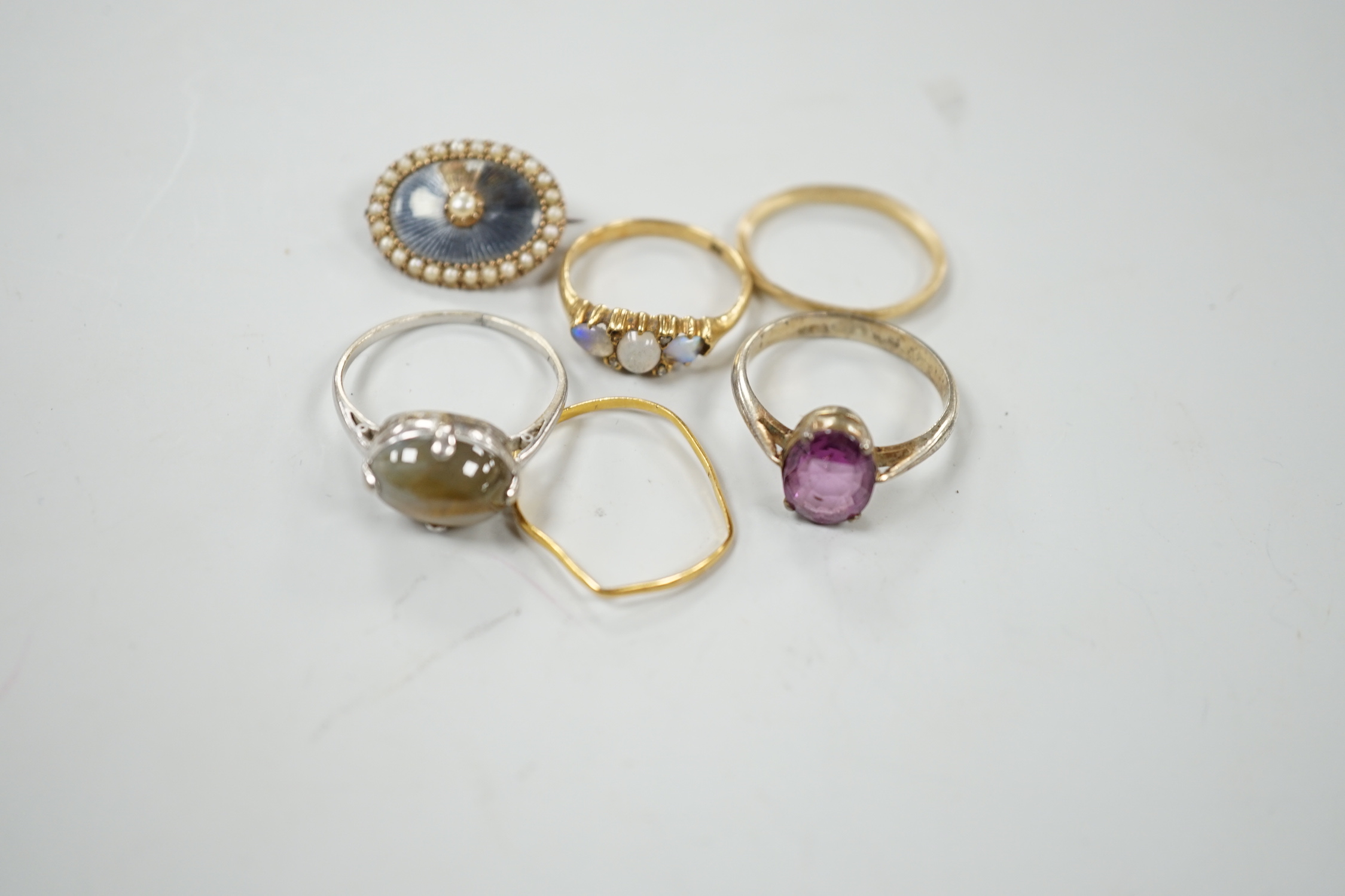 An early 20th century 18ct and three stone white opal set half hoop ring, with diamond chip spacers(one missing), size M, gross weight 2.5 grams, a 9ct band, 1 grams, a 22ct band(a.f.), 0.8 grams, two other rings includi